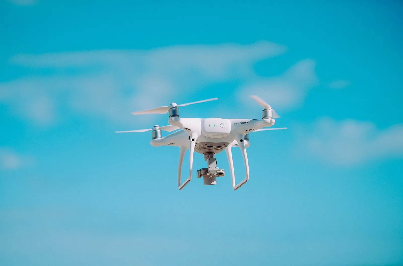 A small consumer camera drone hovering in front of its operator