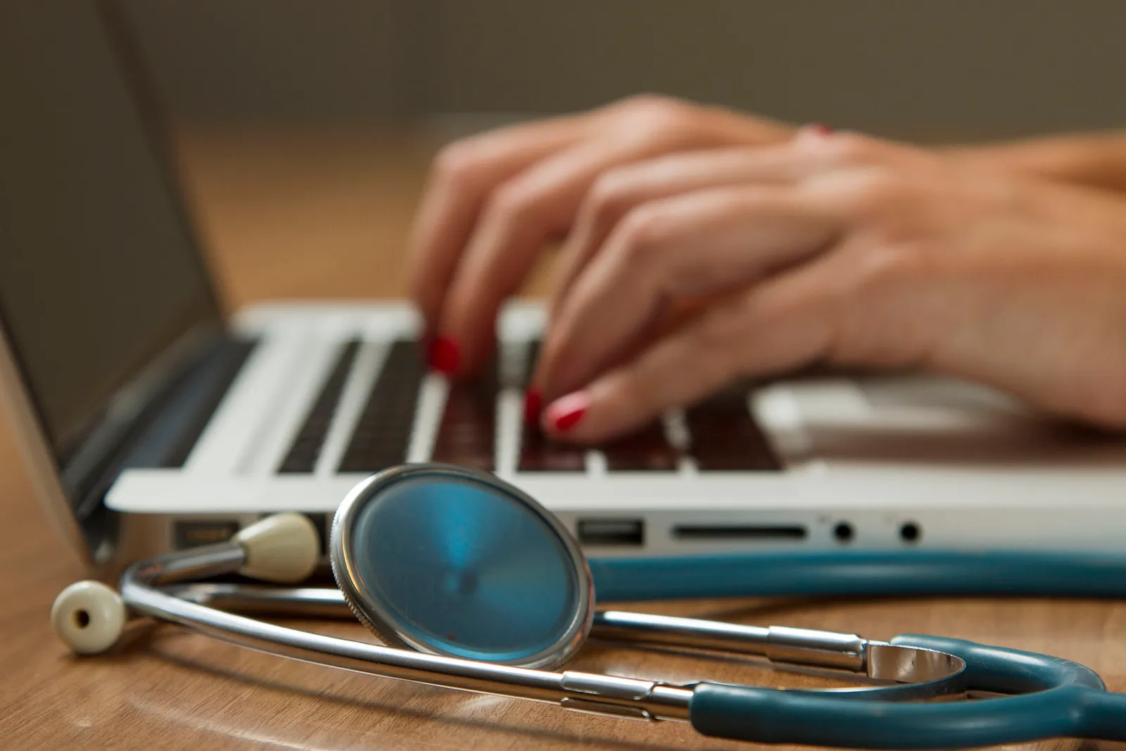 A stethoscope resting on a laptop computer