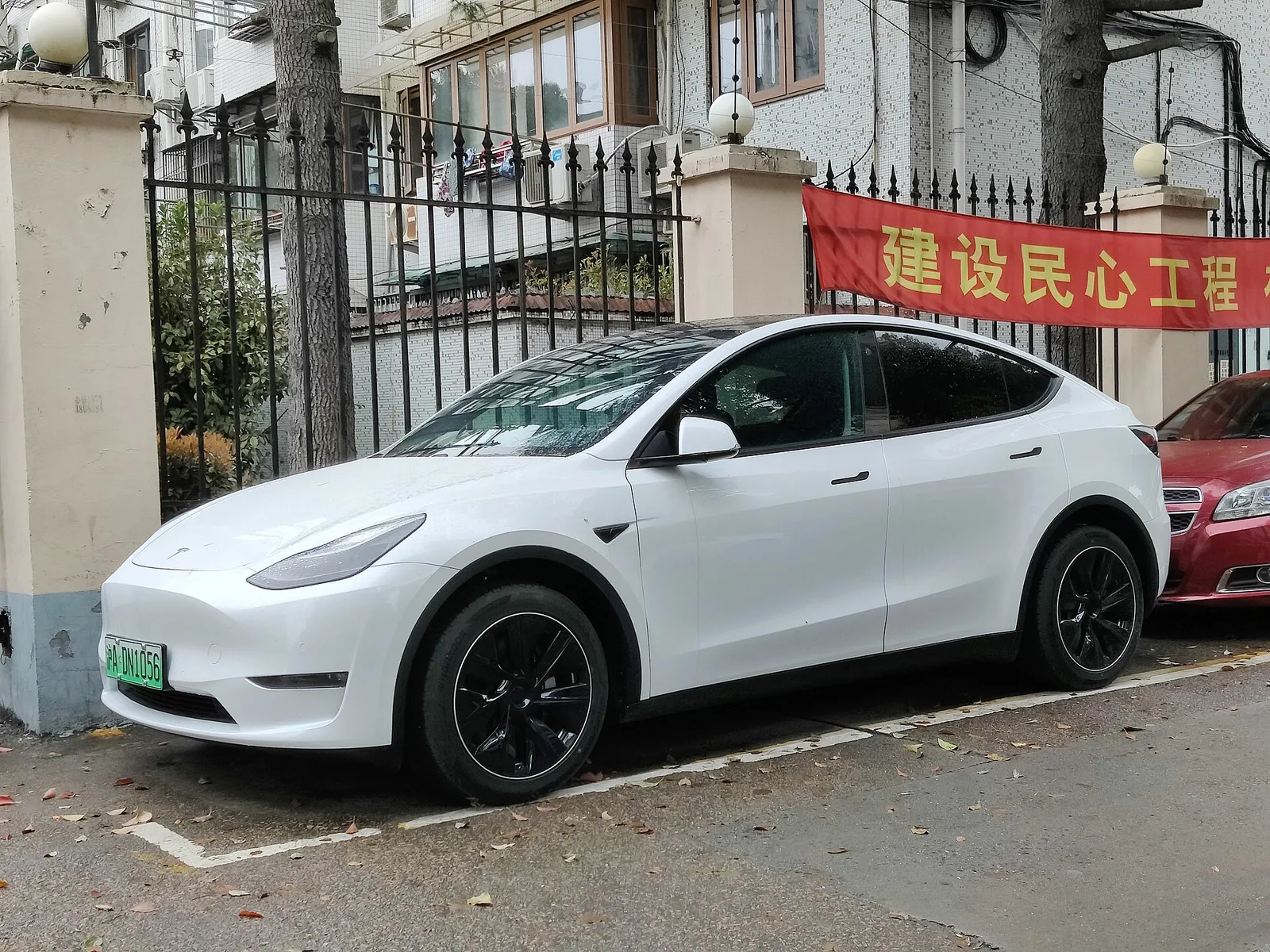 A Tesla Model Y parked on a street in China, its flush door handles visible