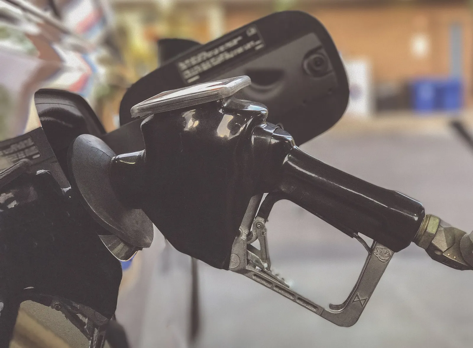 A gas pump nozzle refueling a vehicle