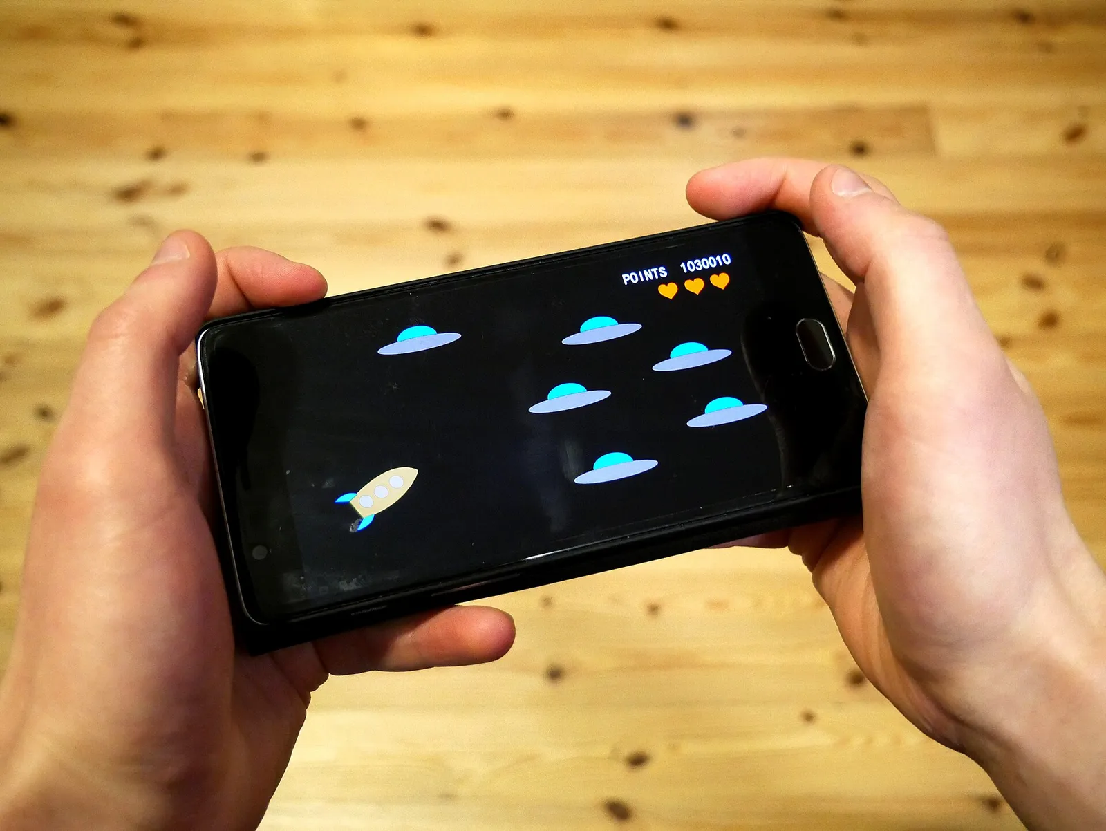 A person playing a game on a smartphone (illustrative photograph)