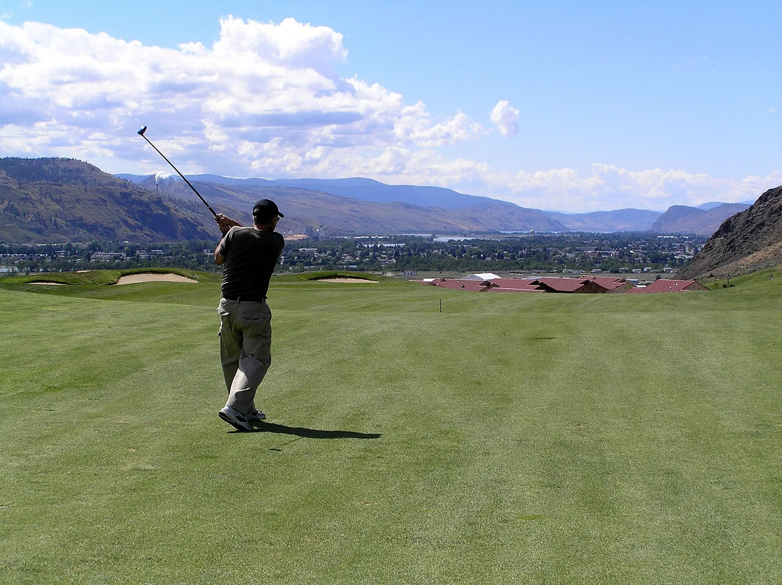 A golfer mid-swing on a course