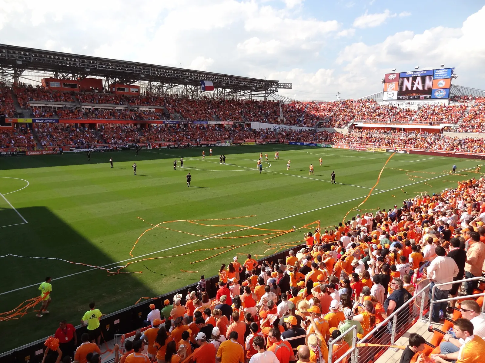 Players celebrate a goal at a football stadium (illustrative)