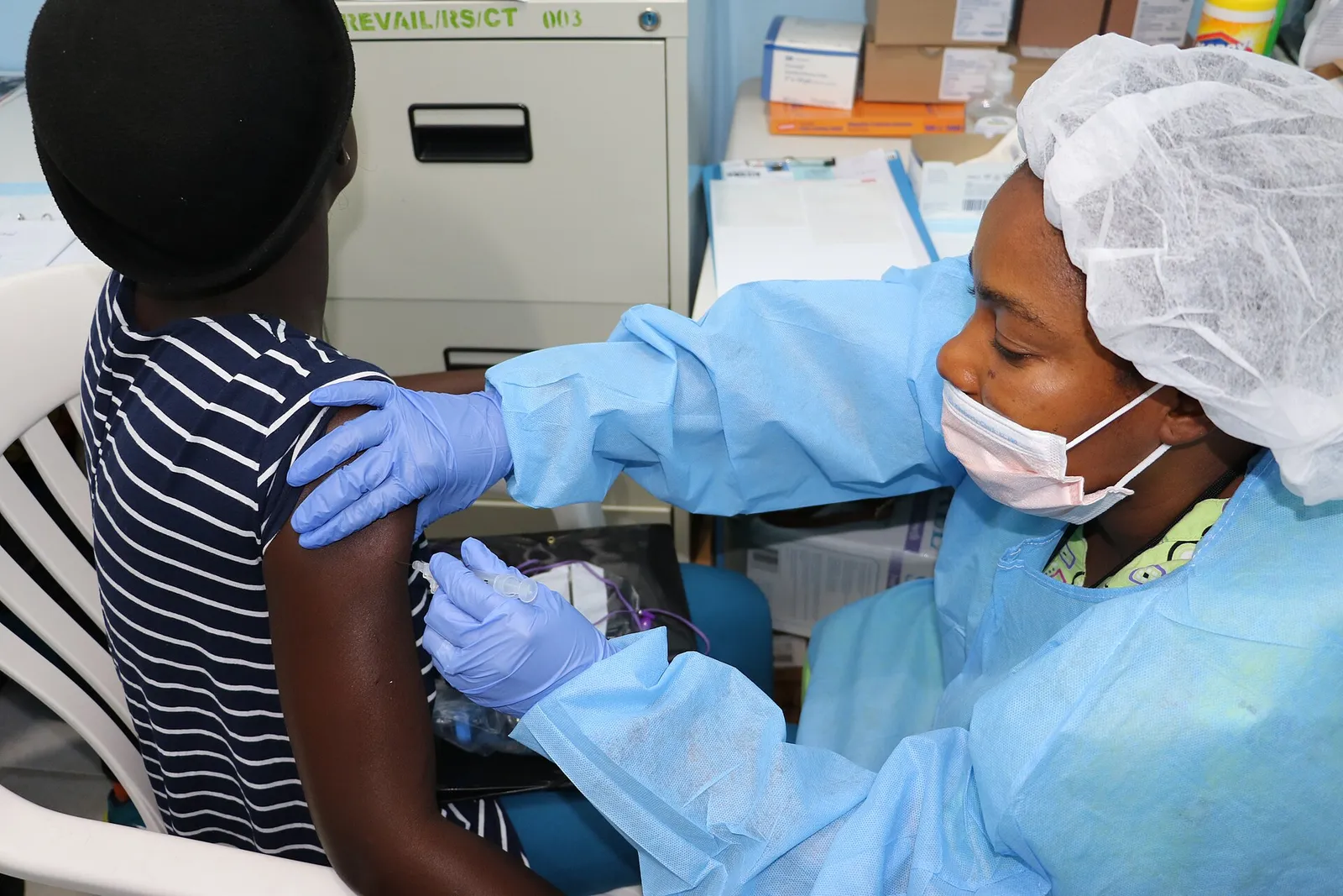 A health worker prepares a dose during an Ebola vaccine study in West Africa
