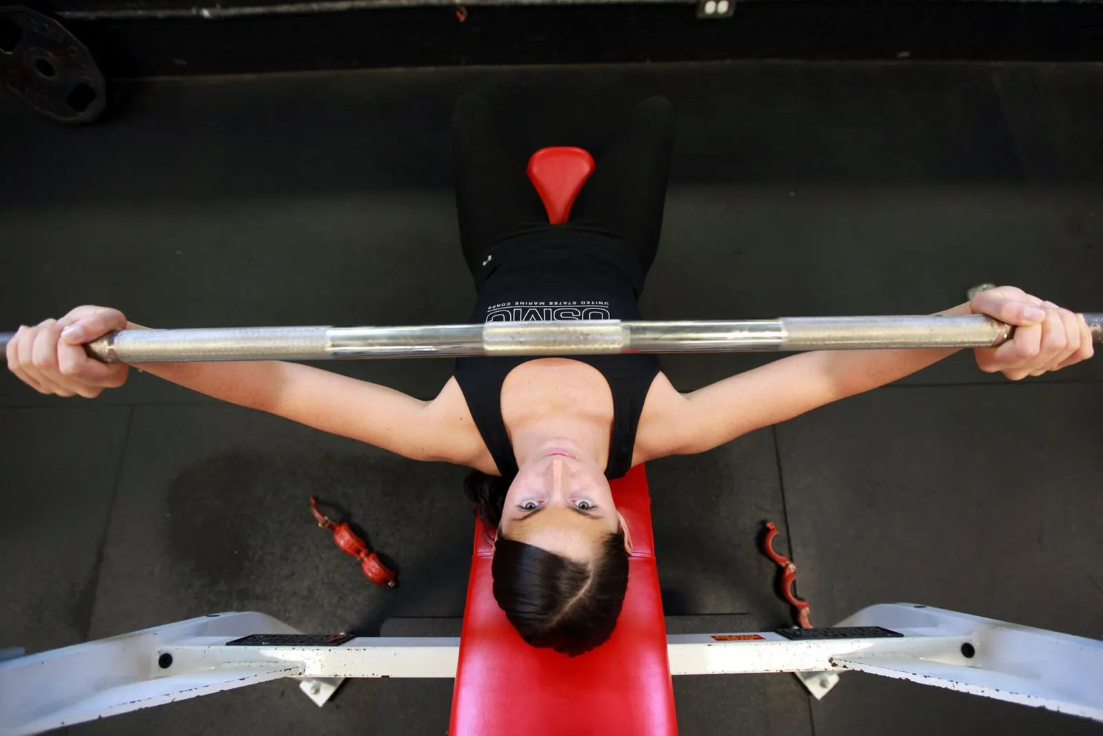 A person lifting a barbell in a gym (illustrative)