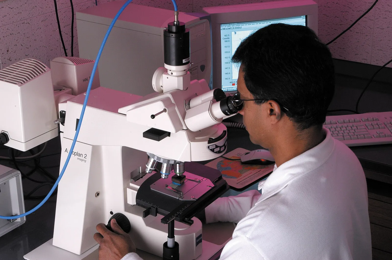 A scientist analyzes a sample under a microscope