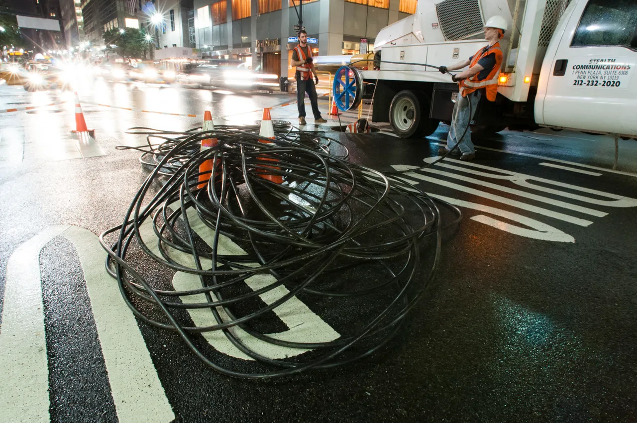A crew installing fiber optic cable beneath a street in Manhattan
