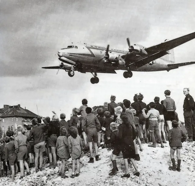 Berliners watch a US C-54 transport plane land at Tempelhof Airport during the Berlin Airlift
