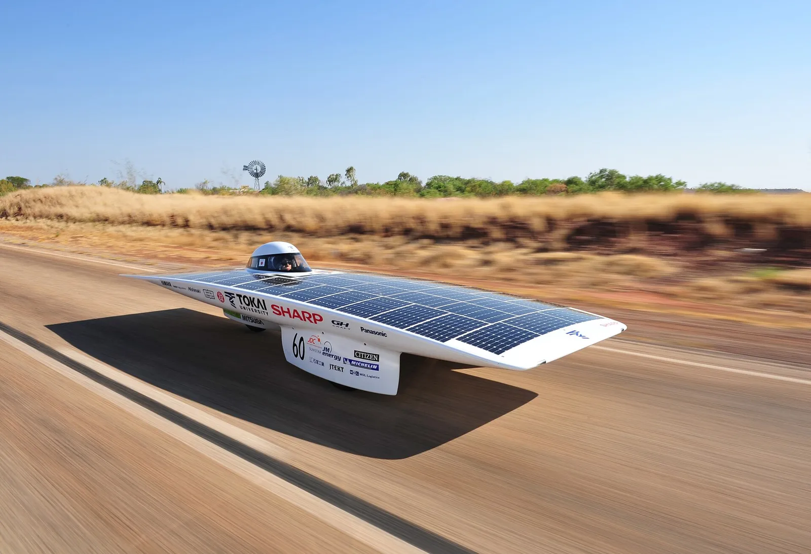 A low, flat solar-powered racing car with a roof-mounted photovoltaic array