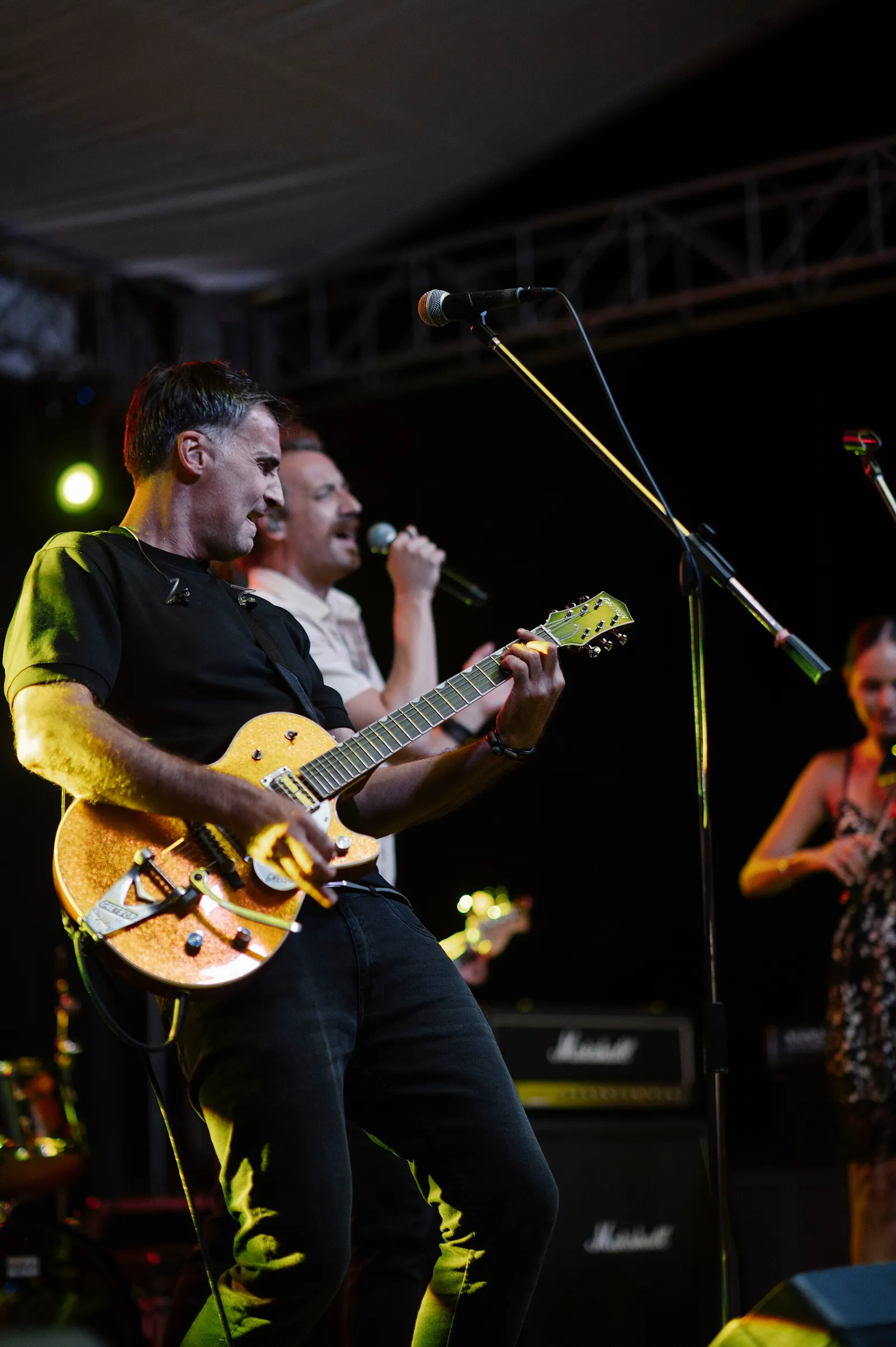 Musicians performing on a brightly lit stage (illustrative)