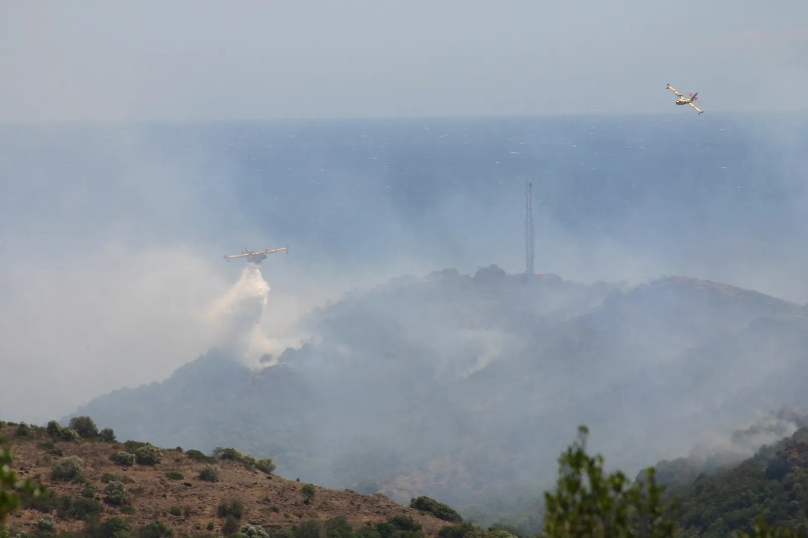 An aircraft dropping water on a wildfire