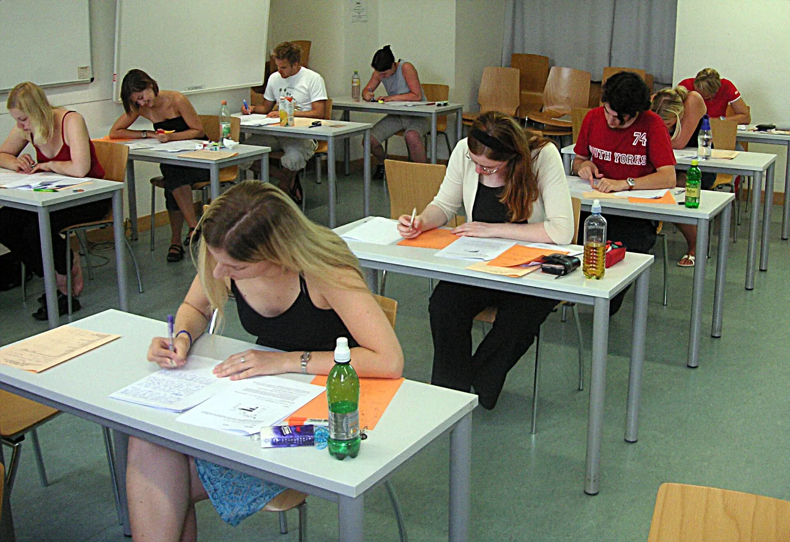Students writing by hand at desks during a written examination