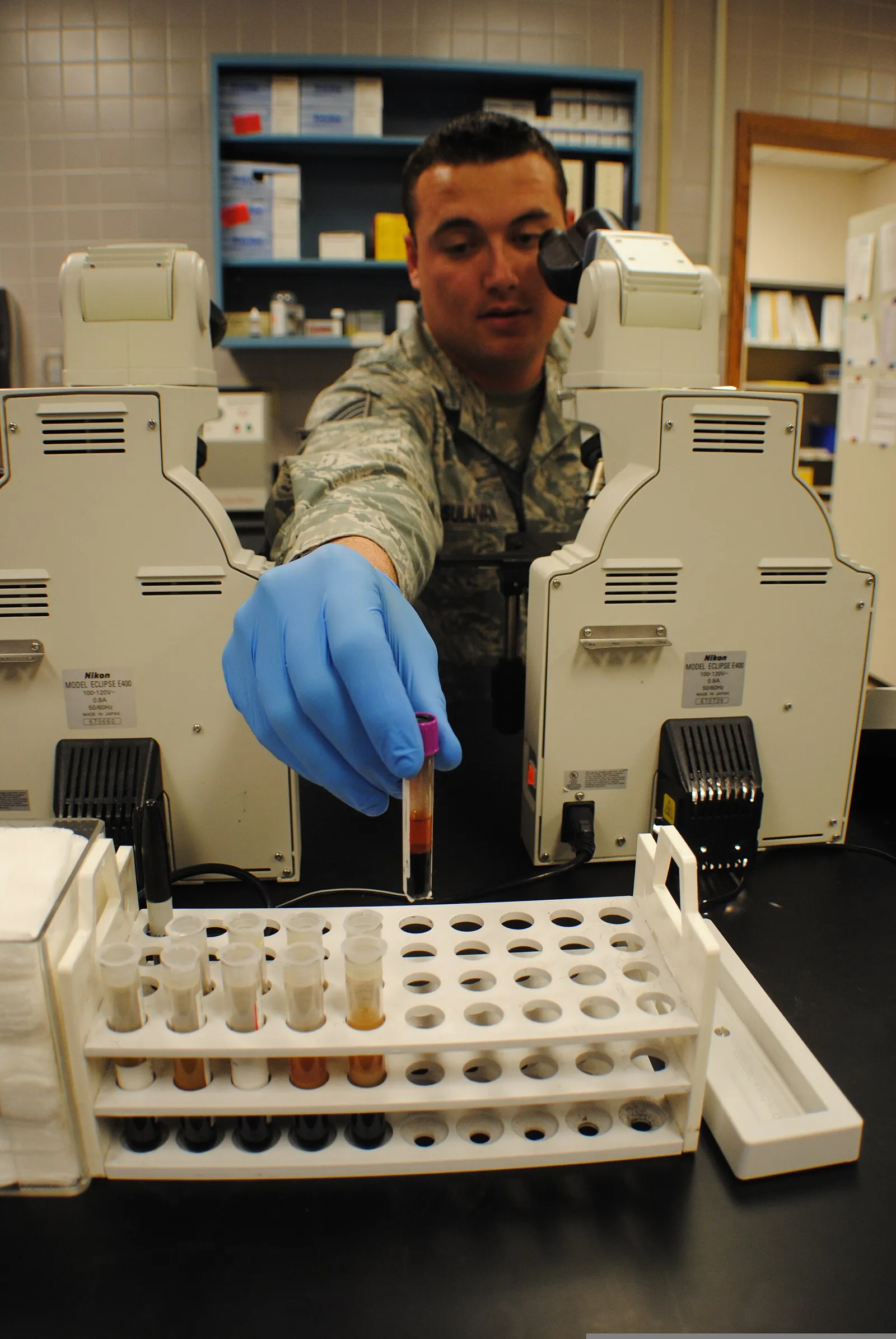 A laboratory technician handling medical samples in test tubes (file image)