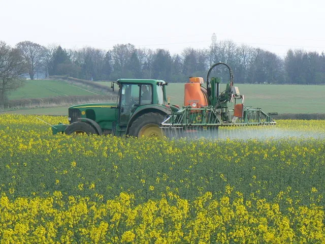 A tractor spraying a crop field