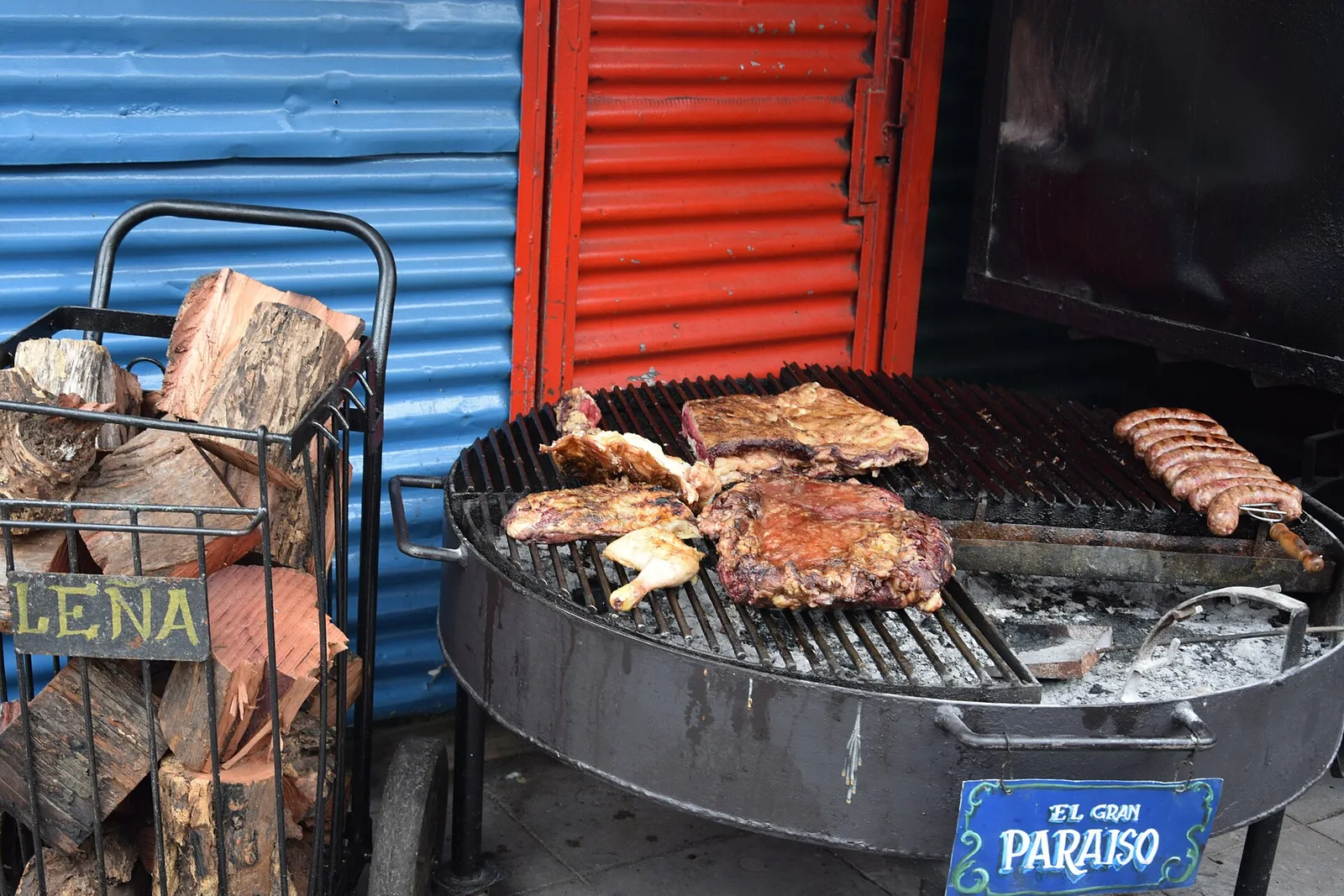 Cuts of beef grilling on an Argentine asado