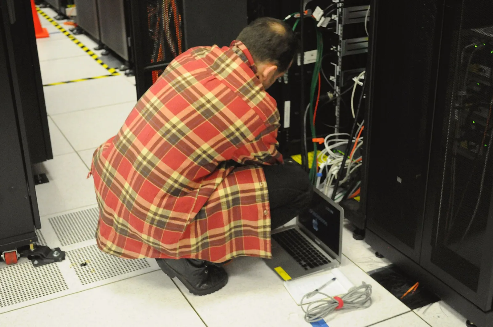 A technician working on a data-center server rack